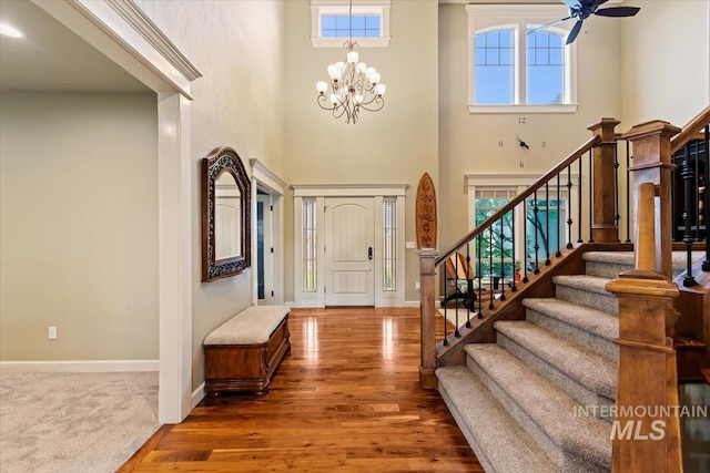 entryway featuring a healthy amount of sunlight, dark hardwood / wood-style floors, and ceiling fan with notable chandelier