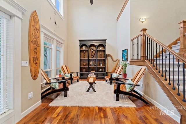 sitting room featuring wood-type flooring and a high ceiling