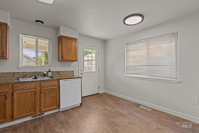 1420 S Denver, Boise, ID 83706 - kitchen featuring white dishwasher, a sink, brown cabinets, light wood-type flooring, and baseboards