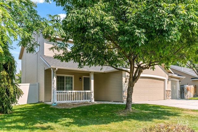 view of front of house with a garage, covered porch, and a front lawn