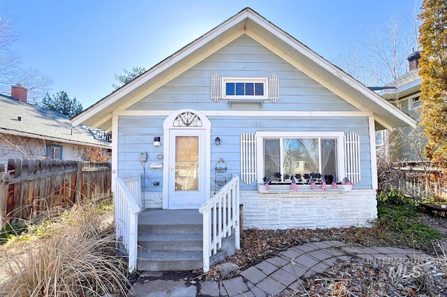 bungalow-style home featuring fence