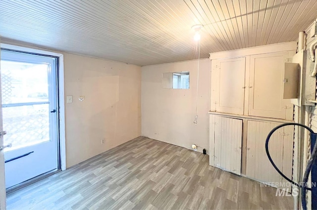 basement featuring light wood-type flooring, wood ceiling, and a healthy amount of sunlight