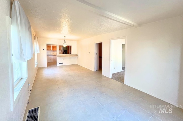 unfurnished room with visible vents and a textured ceiling