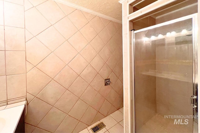 full bathroom with a shower stall and visible vents