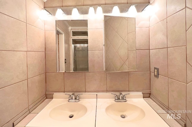 bathroom featuring a sink, tile walls, and double vanity