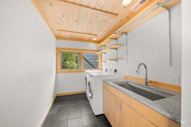 clothes washing area featuring separate washer and dryer, cabinet space, wood ceiling, baseboards, and dark tile patterned floors