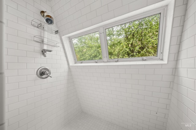 bathroom featuring plenty of natural light and a tile shower
