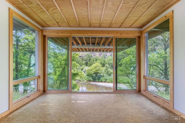 unfurnished sunroom with wooden ceiling and a water view