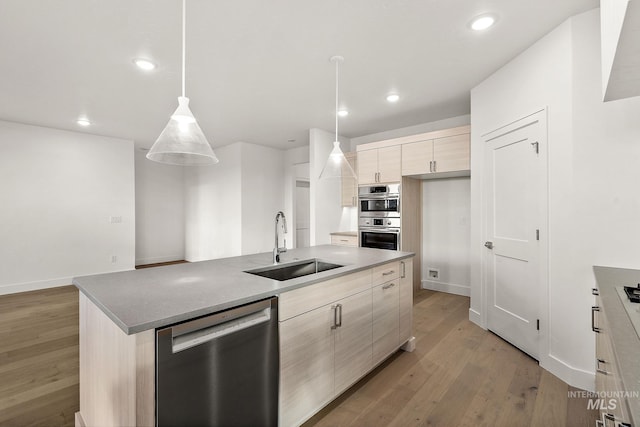 kitchen with appliances with stainless steel finishes, a sink, light wood-style flooring, and modern cabinets