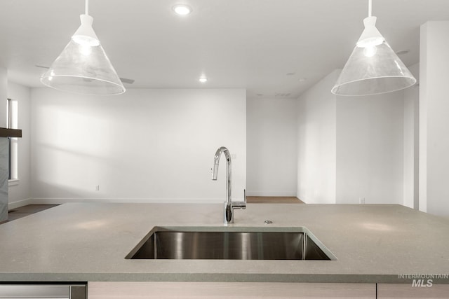 kitchen with recessed lighting, open floor plan, a sink, and hanging light fixtures