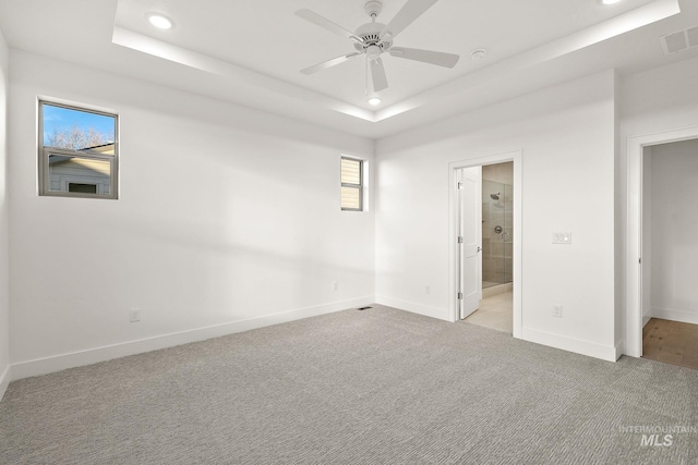 unfurnished bedroom featuring recessed lighting, light colored carpet, visible vents, baseboards, and a tray ceiling