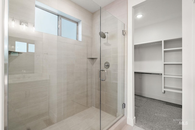 full bath featuring a spacious closet and a stall shower