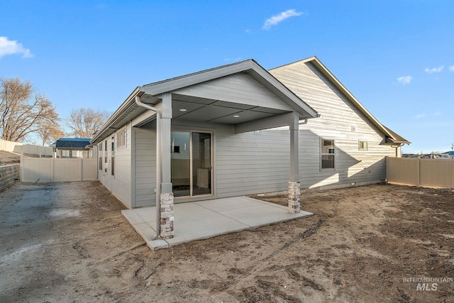 rear view of house featuring a patio area and a fenced backyard