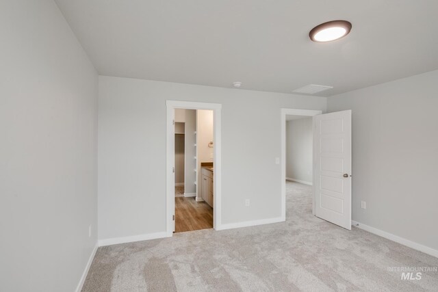 unfurnished bedroom with light colored carpet and baseboards