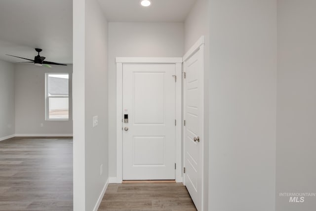 doorway featuring a ceiling fan, recessed lighting, baseboards, and wood finished floors