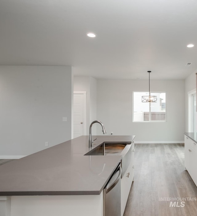 kitchen with recessed lighting, a sink, white cabinets, stainless steel dishwasher, and light wood finished floors