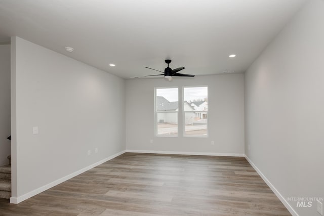 unfurnished room with light wood-style floors, baseboards, and stairway