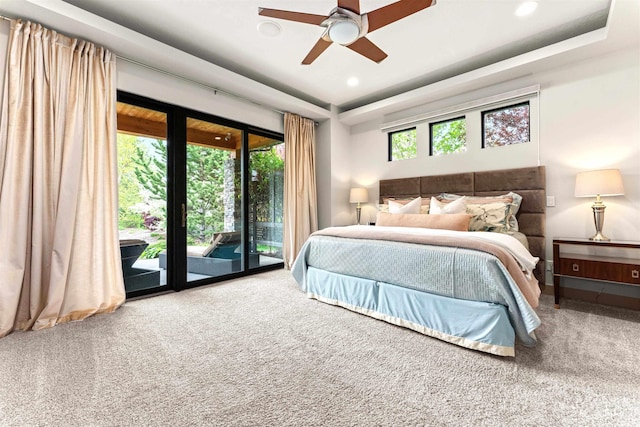 carpeted bedroom featuring recessed lighting, a tray ceiling, access to exterior, and ceiling fan