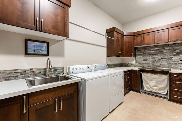 washroom with cabinet space, separate washer and dryer, and a sink