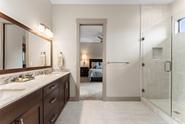 ensuite bathroom featuring double vanity, a ceiling fan, a shower stall, a sink, and ensuite bathroom