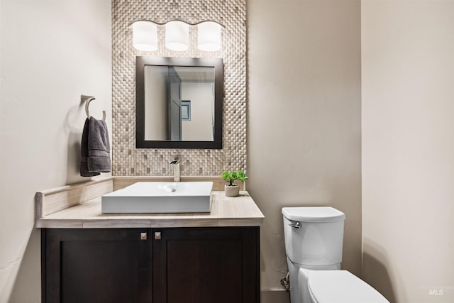 bathroom with vanity, backsplash, and toilet