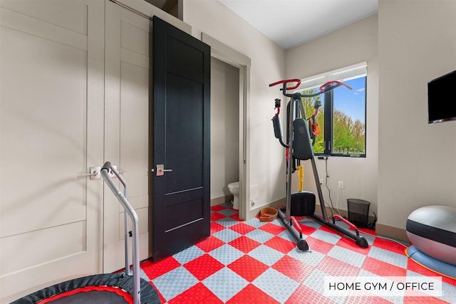 workout room with baseboards and tile patterned floors