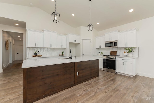 2117 Oxon St, Caldwell, ID 83605 - kitchen featuring stainless steel appliances, decorative backsplash, light countertops, recessed lighting, and high vaulted ceiling