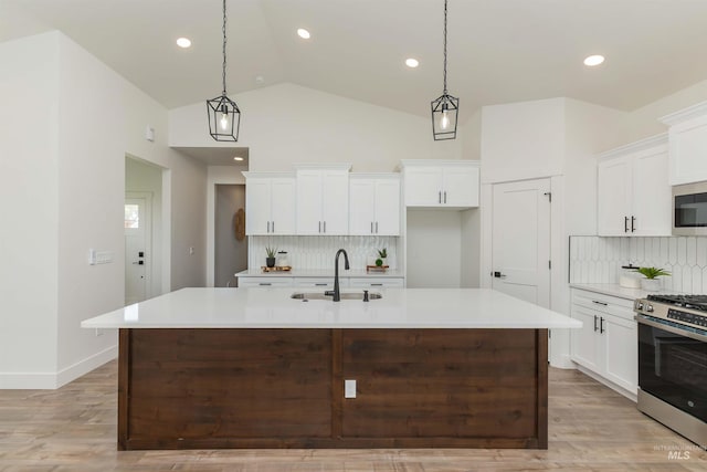 2117 Oxon St, Caldwell, ID 83605 - kitchen featuring appliances with stainless steel finishes, decorative backsplash, vaulted ceiling, light countertops, and white cabinets