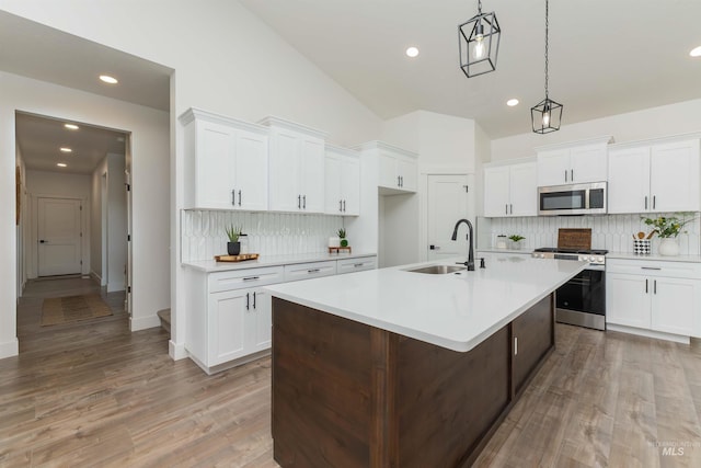 2117 Oxon St, Caldwell, ID 83605 - kitchen with appliances with stainless steel finishes, tasteful backsplash, light countertops, recessed lighting, and white cabinets