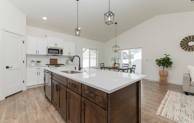 2117 Oxon St, Caldwell, ID 83605 - kitchen featuring appliances with stainless steel finishes, lofted ceiling, light countertops, light wood-type flooring, and white cabinets