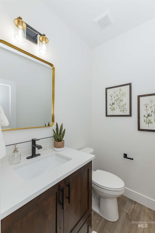 2117 Oxon St, Caldwell, ID 83605 - bathroom featuring vanity, wood finished floors, and decorative backsplash