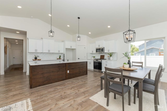 2117 Oxon St, Caldwell, ID 83605 - dining area with a chandelier, light wood finished floors, recessed lighting, and high vaulted ceiling