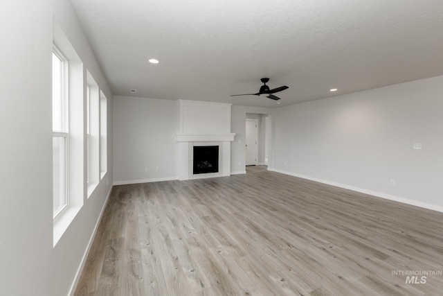 14761 N Ninja Way, Nampa, ID 83651 - unfurnished living room with baseboards, light wood-type flooring, recessed lighting, a textured ceiling, and a ceiling fan