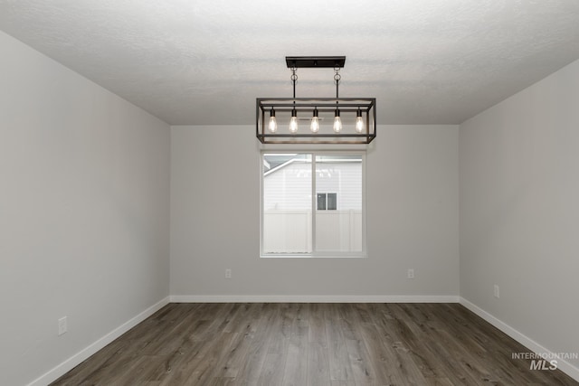 14761 N Ninja Way, Nampa, ID 83651 - unfurnished dining area with a textured ceiling, baseboards, and wood finished floors