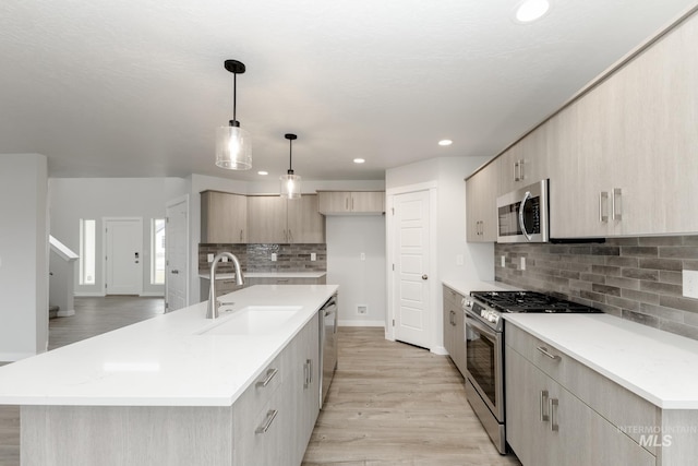 14761 N Ninja Way, Nampa, ID 83651 - kitchen featuring a sink, stainless steel appliances, light countertops, light wood-type flooring, and backsplash