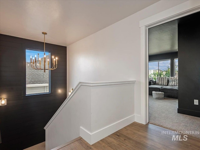 interior space featuring an inviting chandelier, wood finished floors, and baseboards