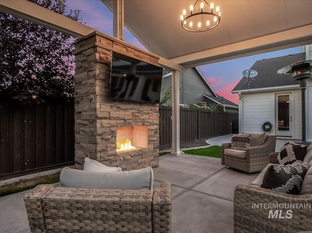 view of patio / terrace with an outdoor living space with a fireplace and a fenced backyard