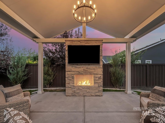 view of patio / terrace featuring an outdoor stone fireplace and a fenced backyard