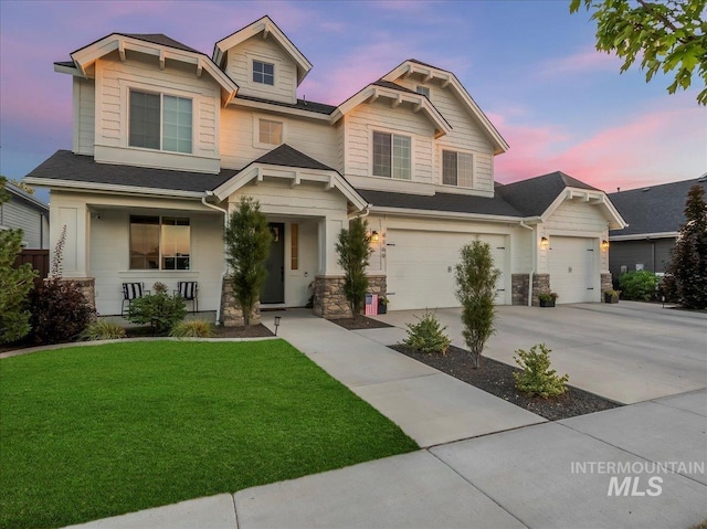 craftsman-style house with concrete driveway, stone siding, an attached garage, a porch, and a yard