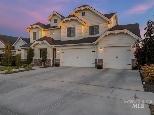 craftsman-style house featuring stone siding, a garage, and concrete driveway
