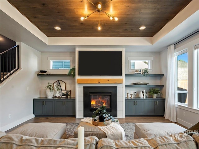 living room featuring wood ceiling, plenty of natural light, and a tray ceiling