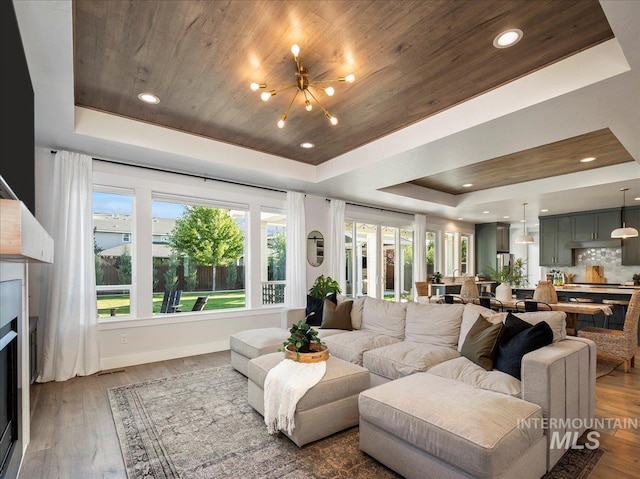 living room with a raised ceiling, plenty of natural light, and wood finished floors