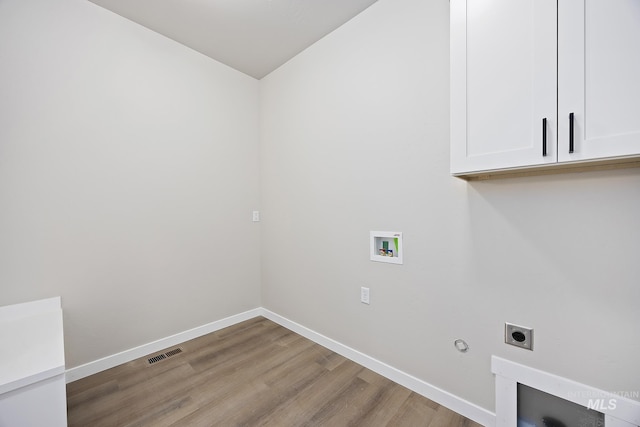 laundry room featuring light hardwood / wood-style floors, cabinets, electric dryer hookup, and washer hookup
