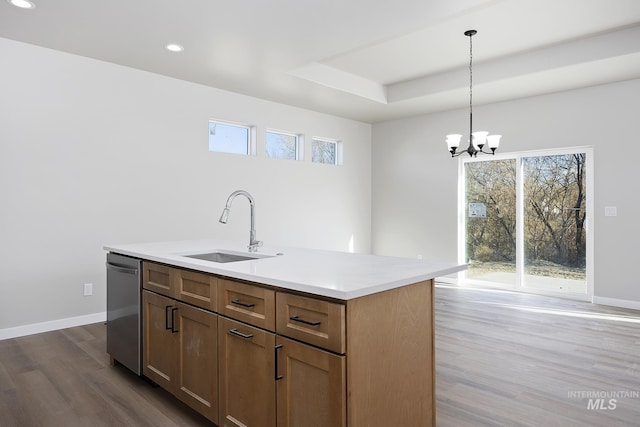 kitchen featuring a kitchen island with sink, stainless steel dishwasher, sink, pendant lighting, and a healthy amount of sunlight