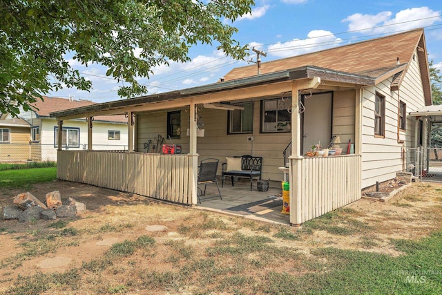 back of house with a lawn and a patio