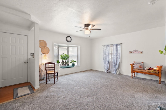 foyer with hardwood / wood-style floors, ceiling fan, and a textured ceiling