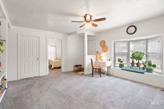 unfurnished room featuring ceiling fan, carpet, and a textured ceiling