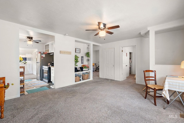 living area with ceiling fan and carpet