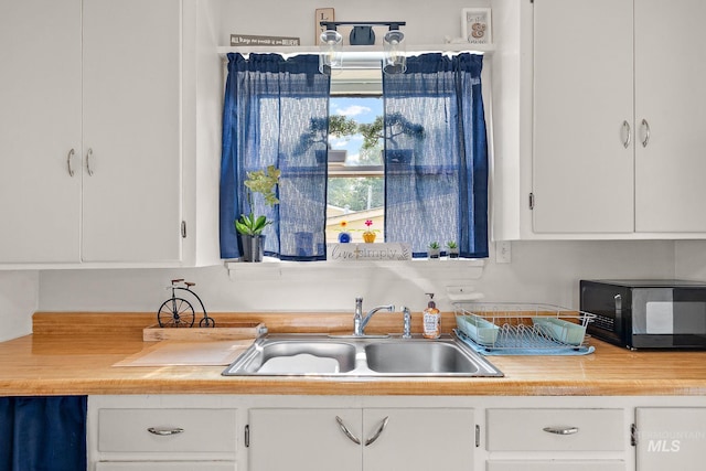 kitchen featuring white cabinetry and sink