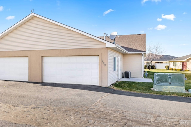 exterior space featuring a garage and cooling unit